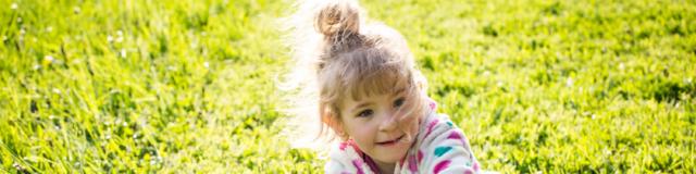 Petite fille jouant dans l'herbe < Soissons